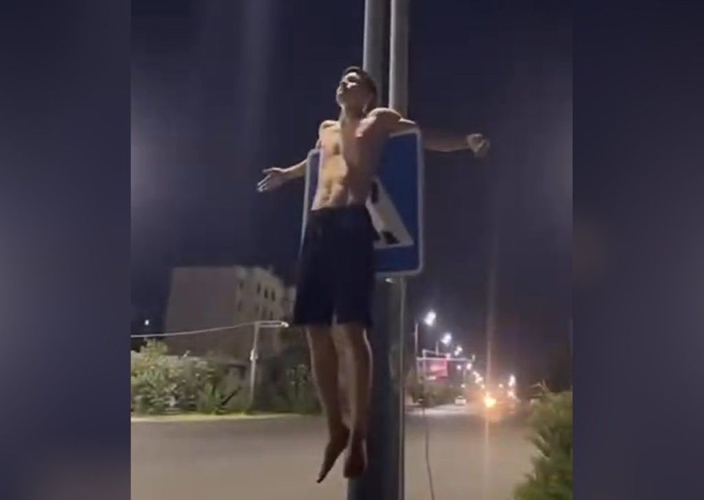 Дно хайпа пробито. В Термезе подросток "распял" себя на дорожном знаке пешеходного перехода. Видео